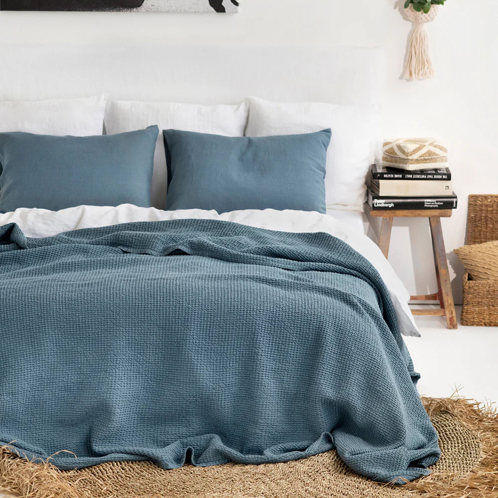 Waffle Weave Bed Blanket in Slate Gray Blue on a bed with white sheets in a room with white walls and a jute rug