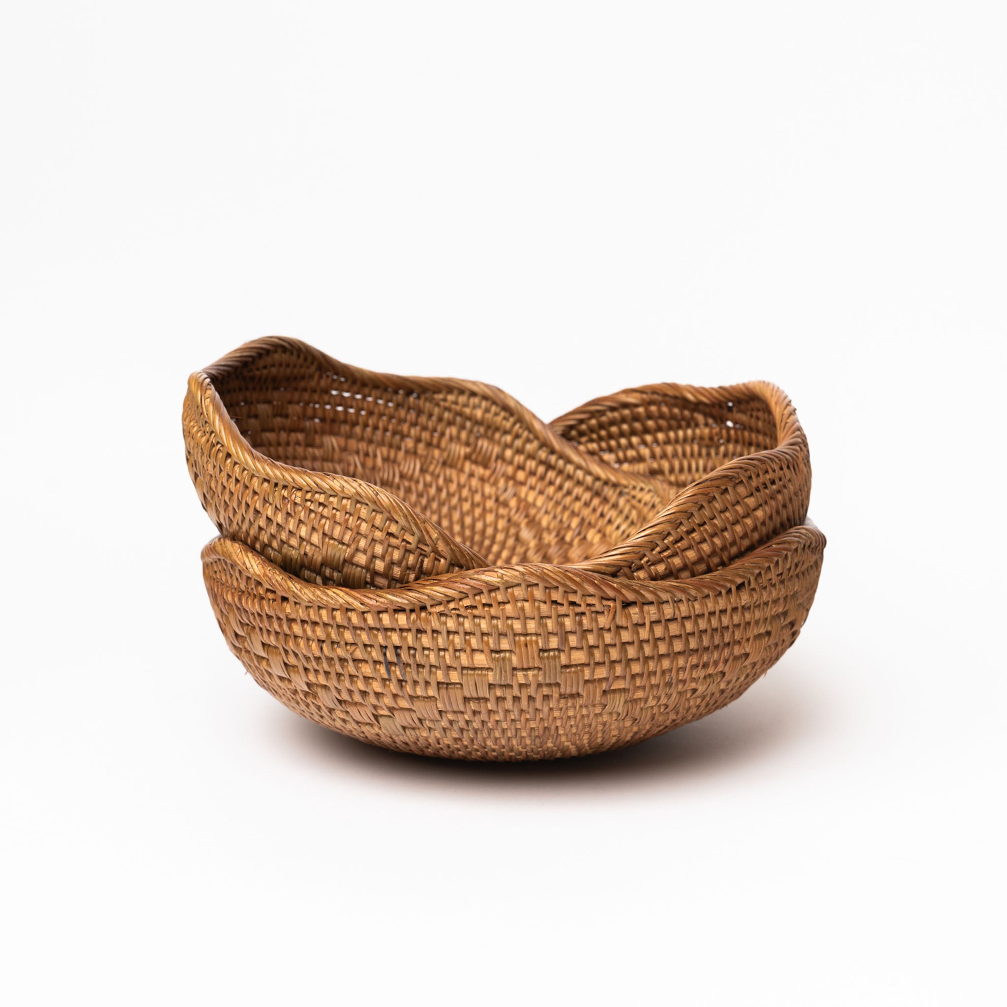 Set of 3 hand woven rattan nesting bowls with wavy lip by bloomingville on a white background