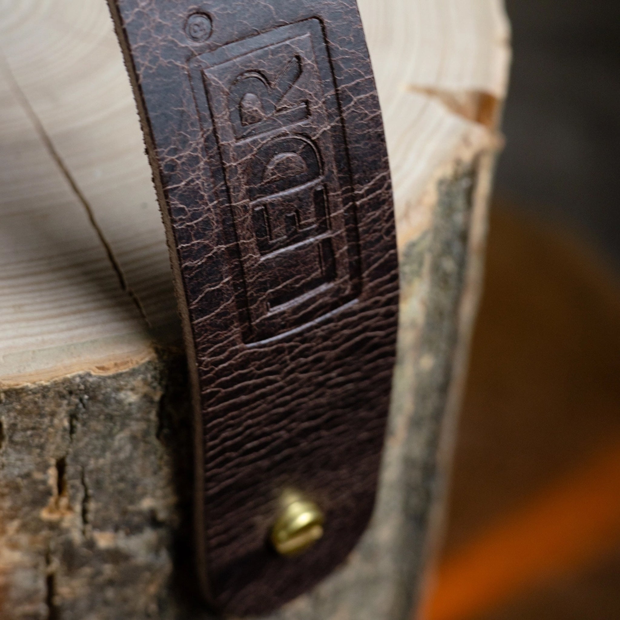 Close up of LEDR Medium Ash Wood Trunk Light with Leather Strap on a wood table at Addison West