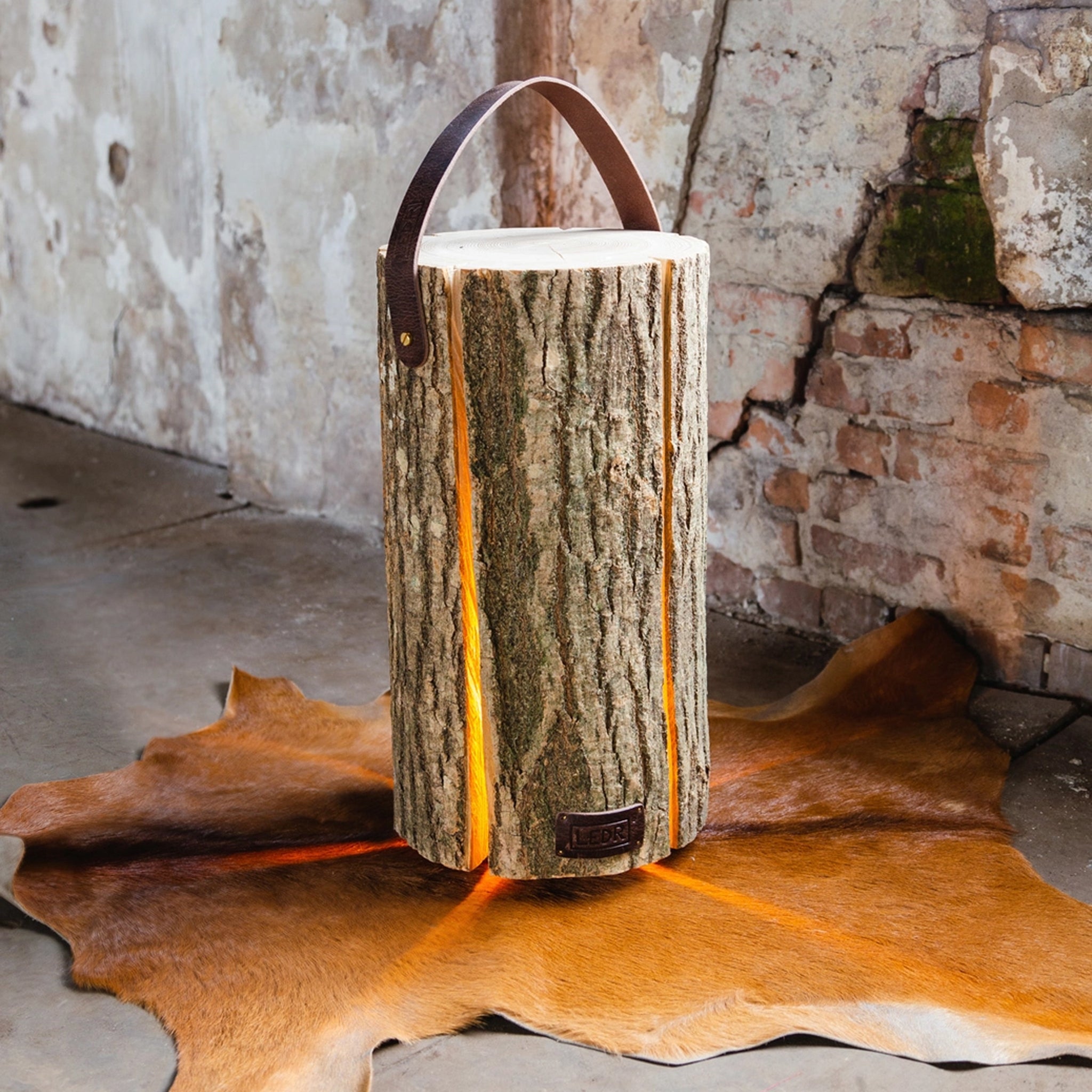 Large Ash Wood Trunk Light with Leather Strap on a hide rug at Addison West