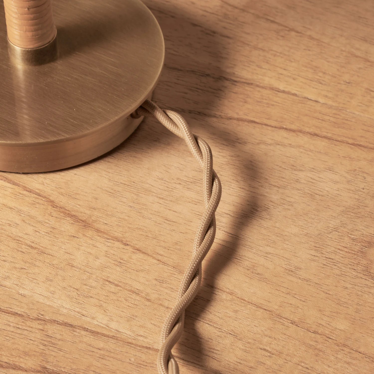 Close up of cord of Woven Delphine Mini Table Lamp on a wood table at Addison West