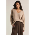 Model wearing brown pants and Z Supply All I Want V-Neck Sweater in Heather Taupe in front of a neutral backdrop