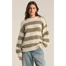 Model wearing Z Supply Anders Stripe Sweater in Willow with baggie jeans in front of a neutral backdrop