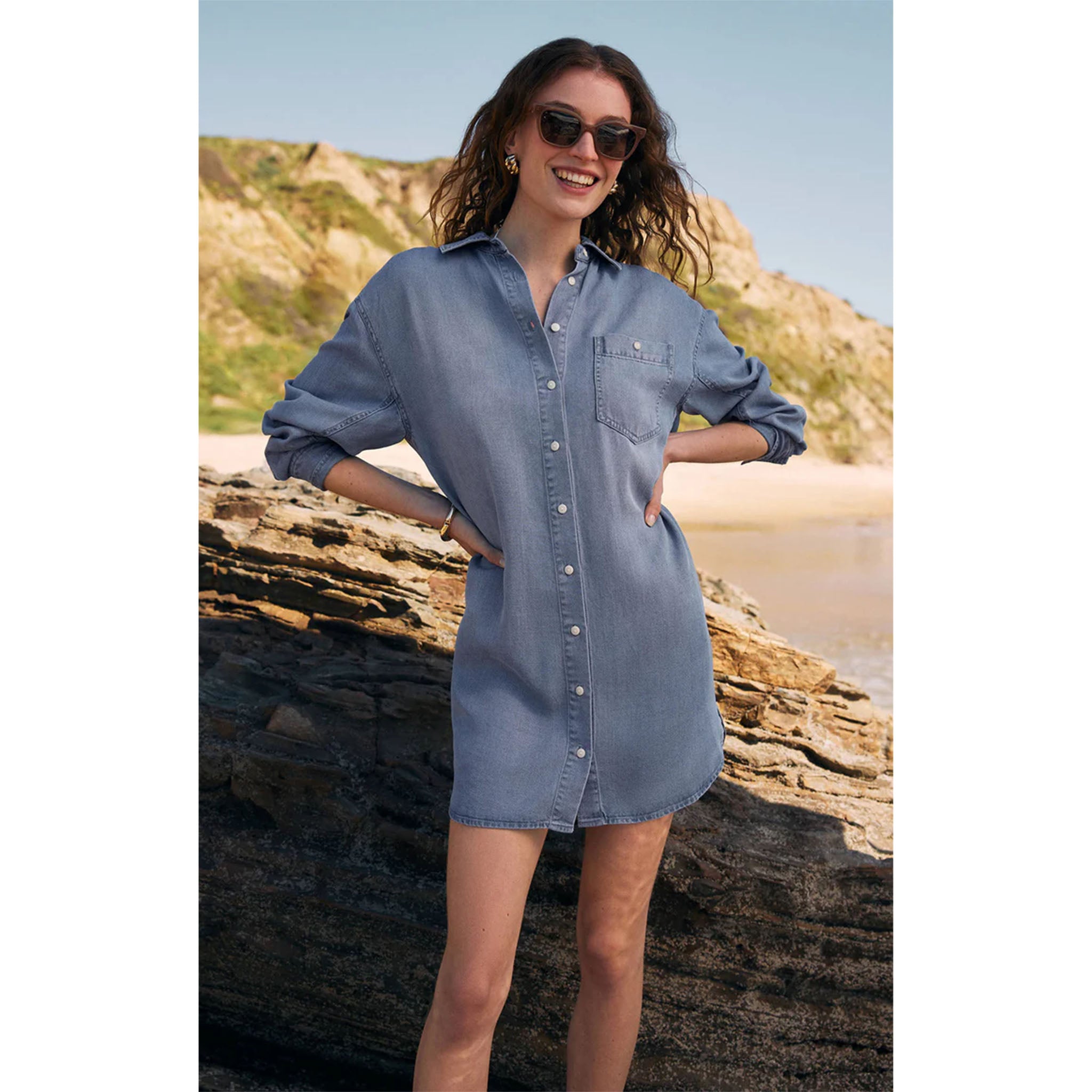 Model wearing Z Supply Dover Chambray Dress Sun Bleached Indigo with sunglasses on a beach