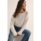 Model wearing Z Supply Emerson Sweater in White with wide leg jeans in front of a white background