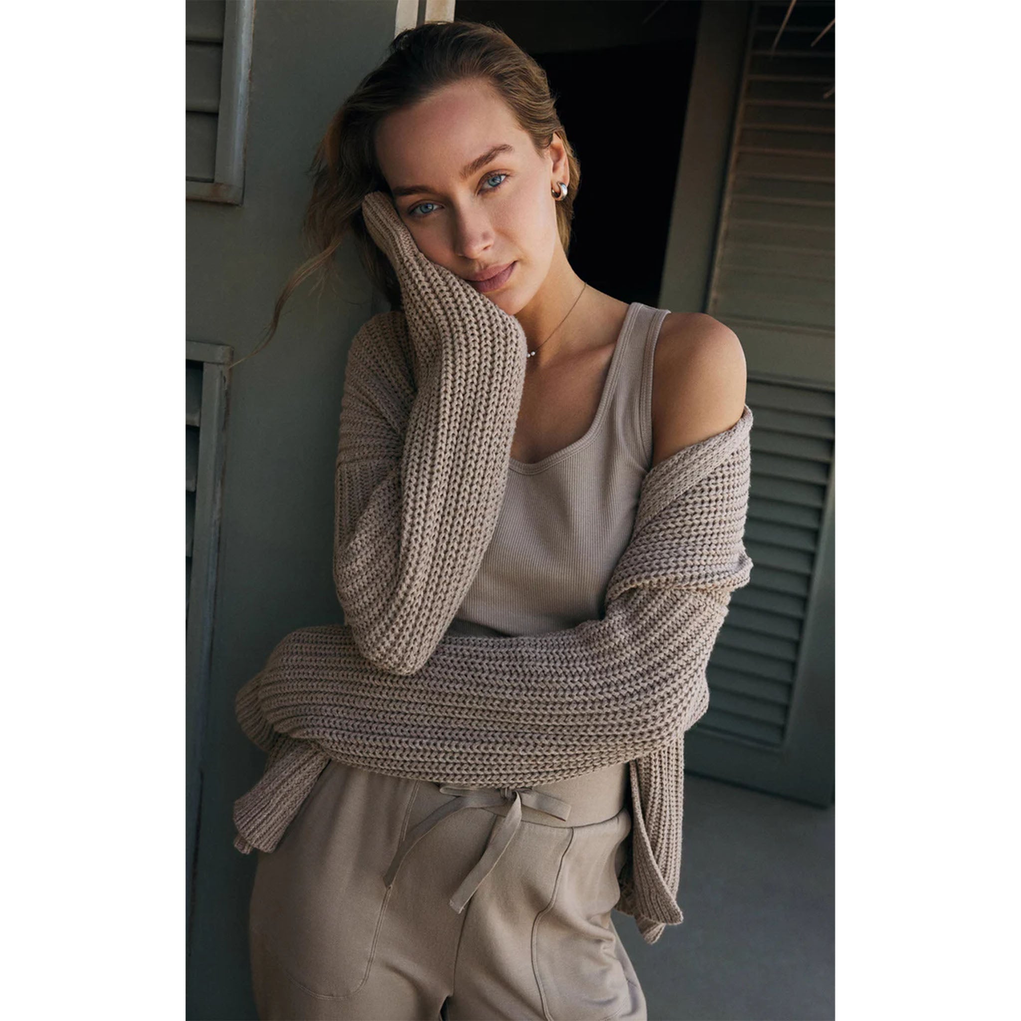 Model wearing Z Supply Essy Rib Top Slate in Grey with matching sweater and joggers in front of a green door 