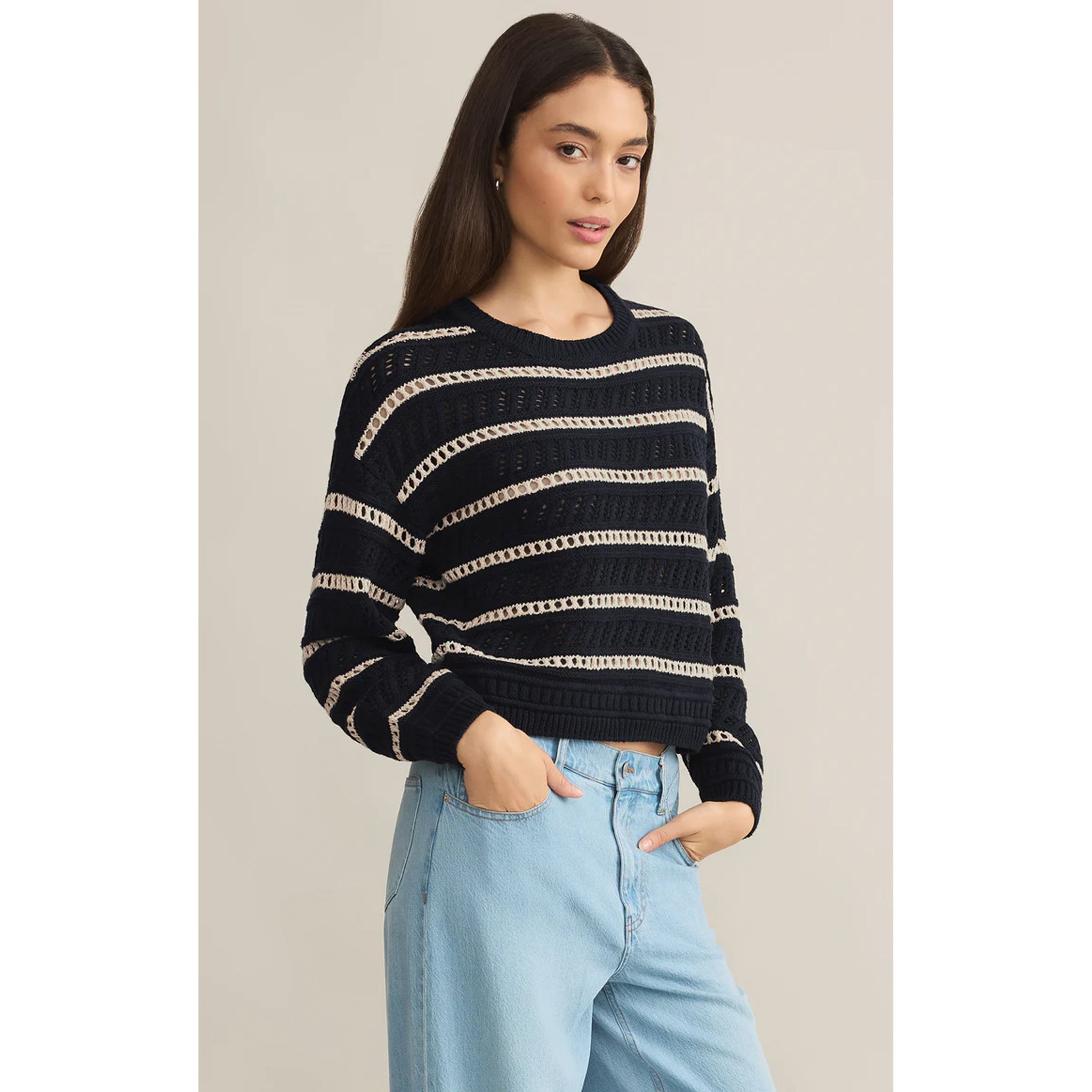 Model wearing Z Supply Estero Stripe Sweater Eclipse with light blue jeans in front of a neutral backdrop