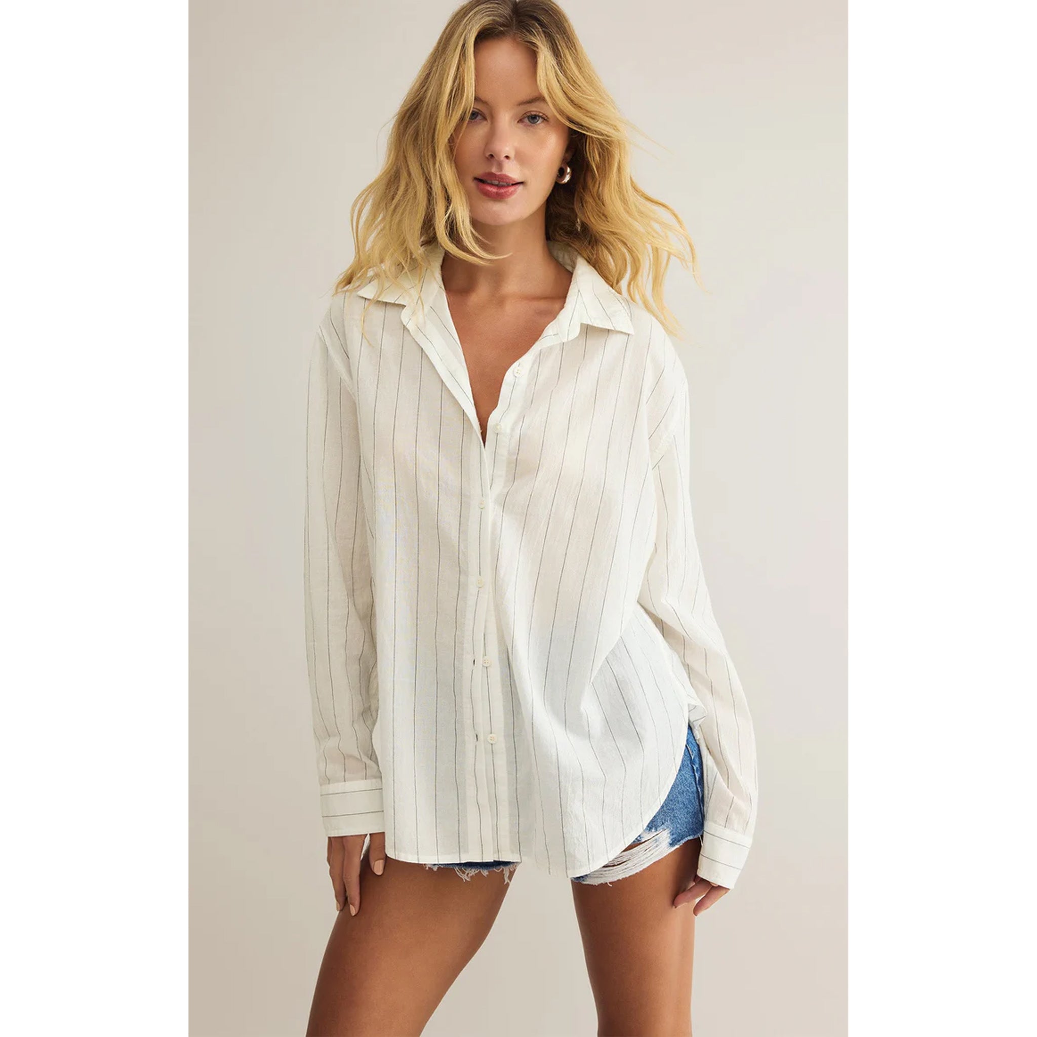 Model wearing Z Supply Seaport Striped Shirt in White with jean shorts in front of a neutral backdrop