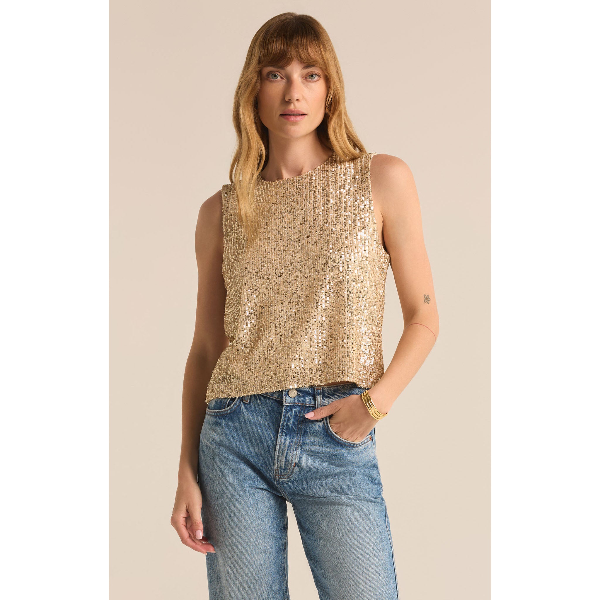 Model wearing Z Supply Sloane Sequin Top in Champagne with jeans in front of a neutral backdrop