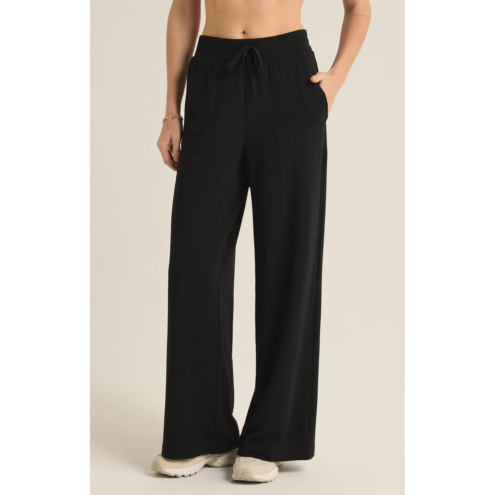 Model wearing Z Supply Layover Pant in Black in front of a beige background