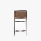 Back view of Four hands brand wharton counter stool with black iron frame and dark brown leather seat on a white background