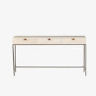 Four hands brand Trey Modular writing desk with whitewashed wood and three drawers with leather pulls and iron base on a white background