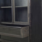 Close up of Black riveted metal and wood cabinet with glass doors and curved top on a white background