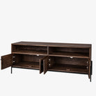 Brown wood media console with black metal legs and four doors and rustic pulls on a white background