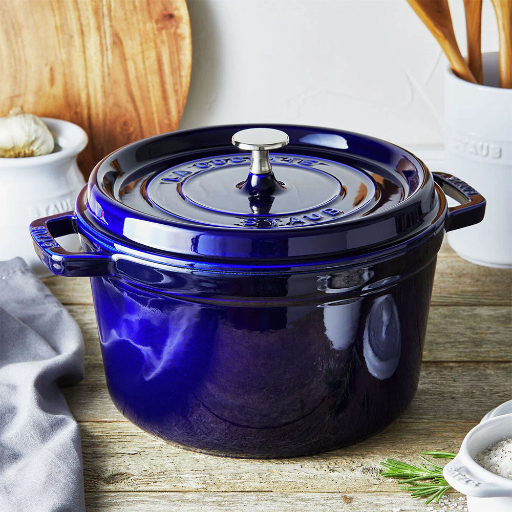 Blue Staub five quart cast iron dutch oven on a wood counter