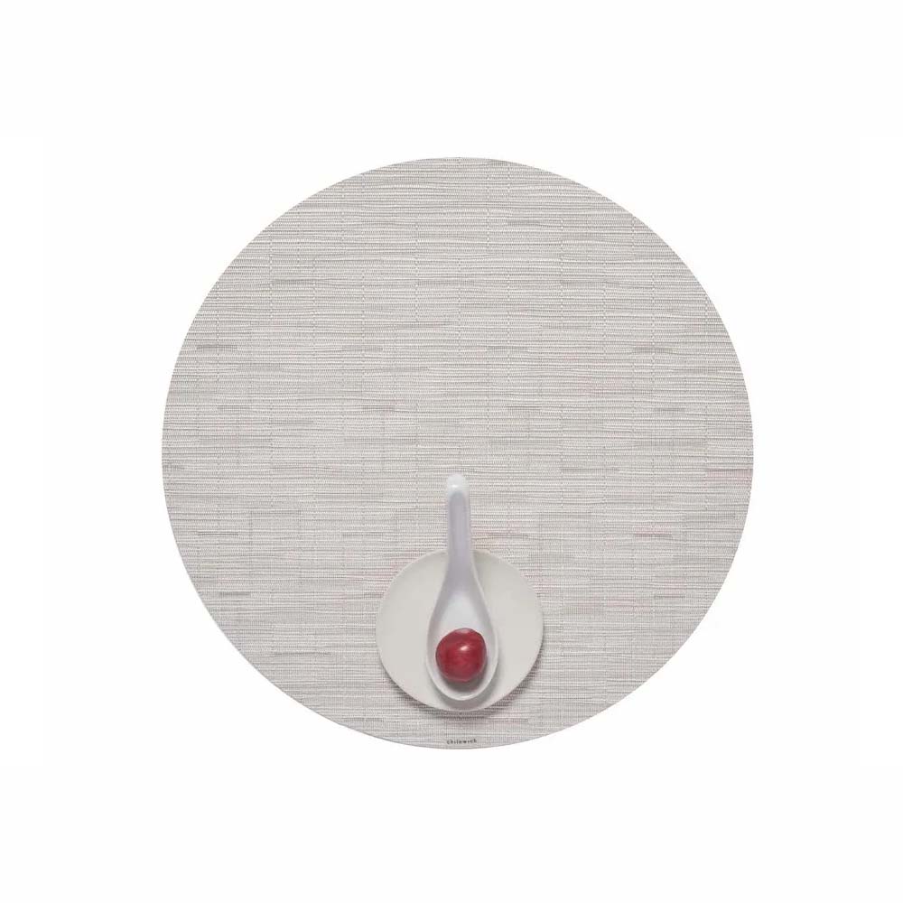 Chilewich Bamboo Signature round placemat in coconut on a white background with a small plate and white spoon