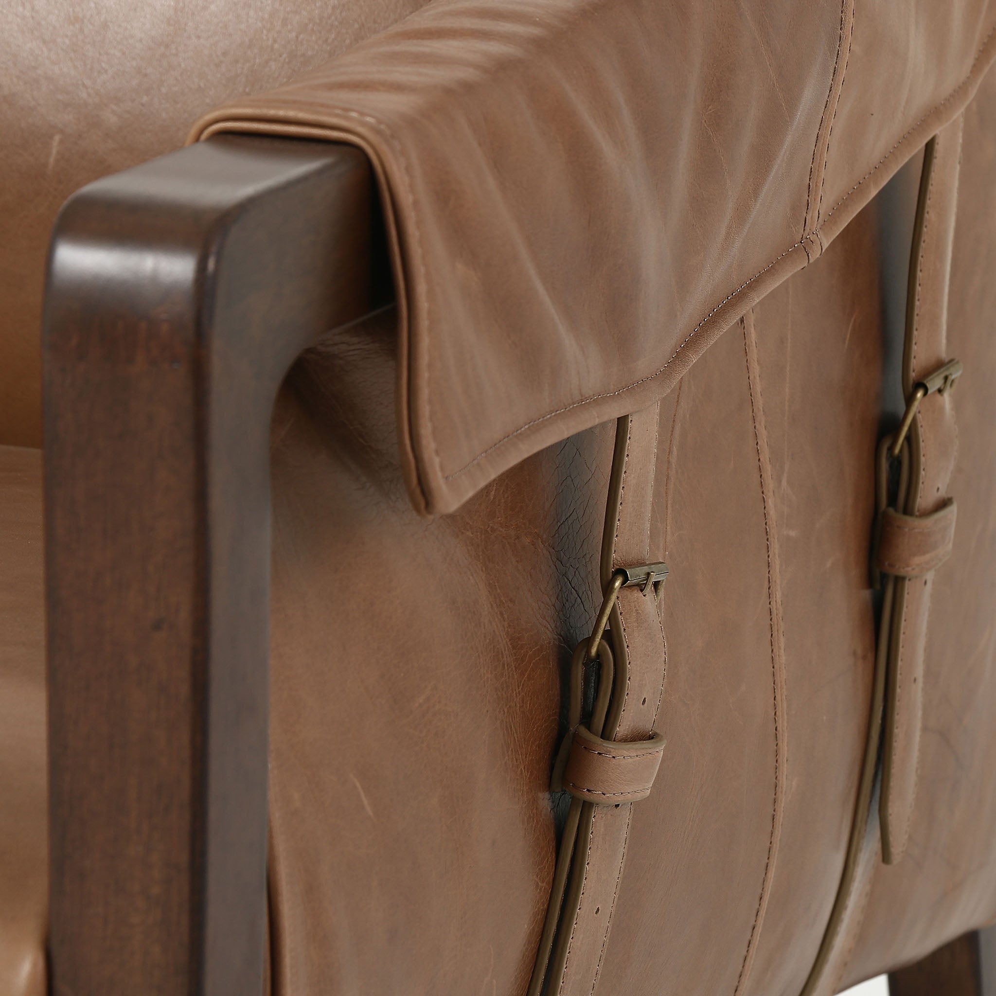 Four Hands Furniture brand Bauer chair in taupe leather with stained wood legs and leather buckled straps on a white background