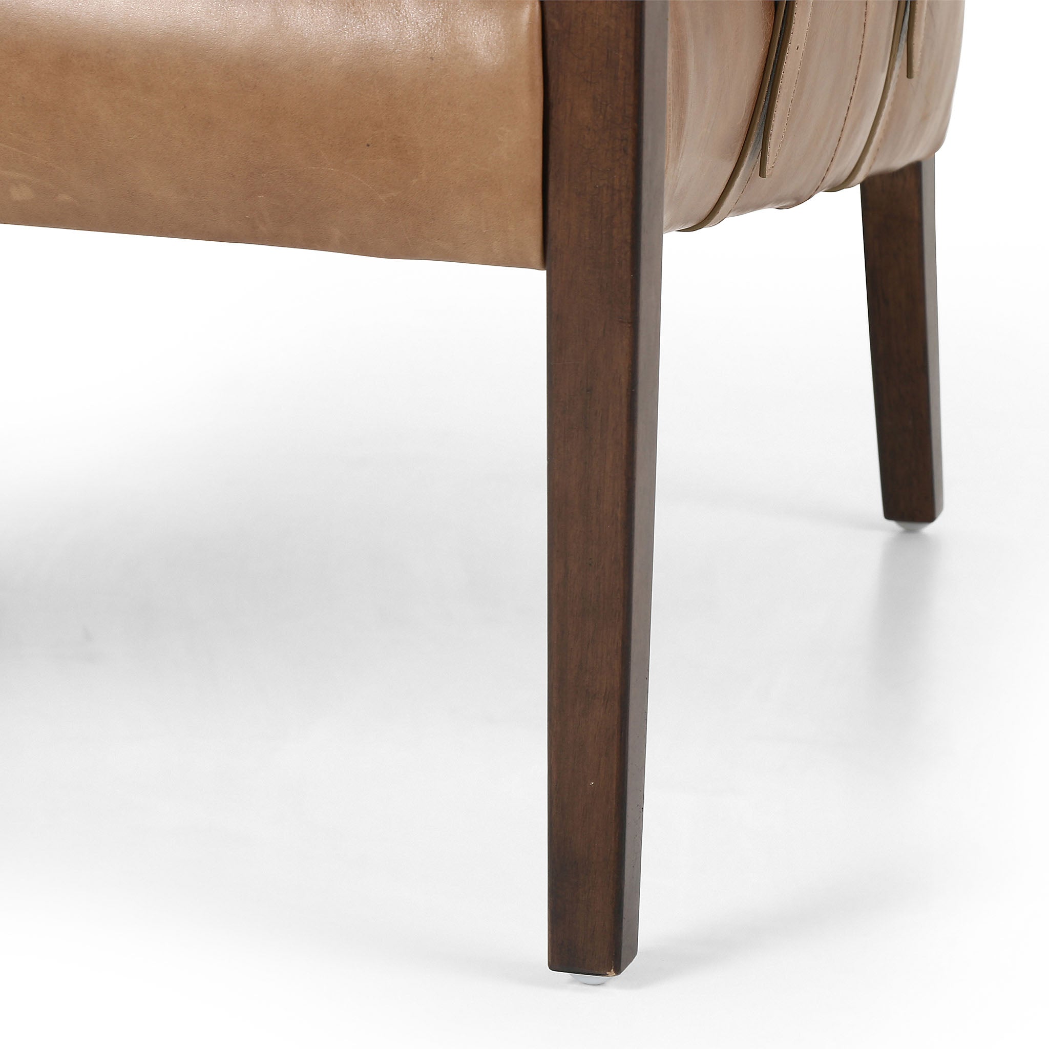 Four Hands Furniture brand Bauer chair in taupe leather with stained wood legs and leather buckled straps on a white background