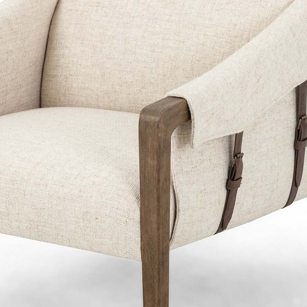 Close up of Four Hands Furniture brand Bauer chair in thames cream with stained wood legs and leather buckled straps on a white background