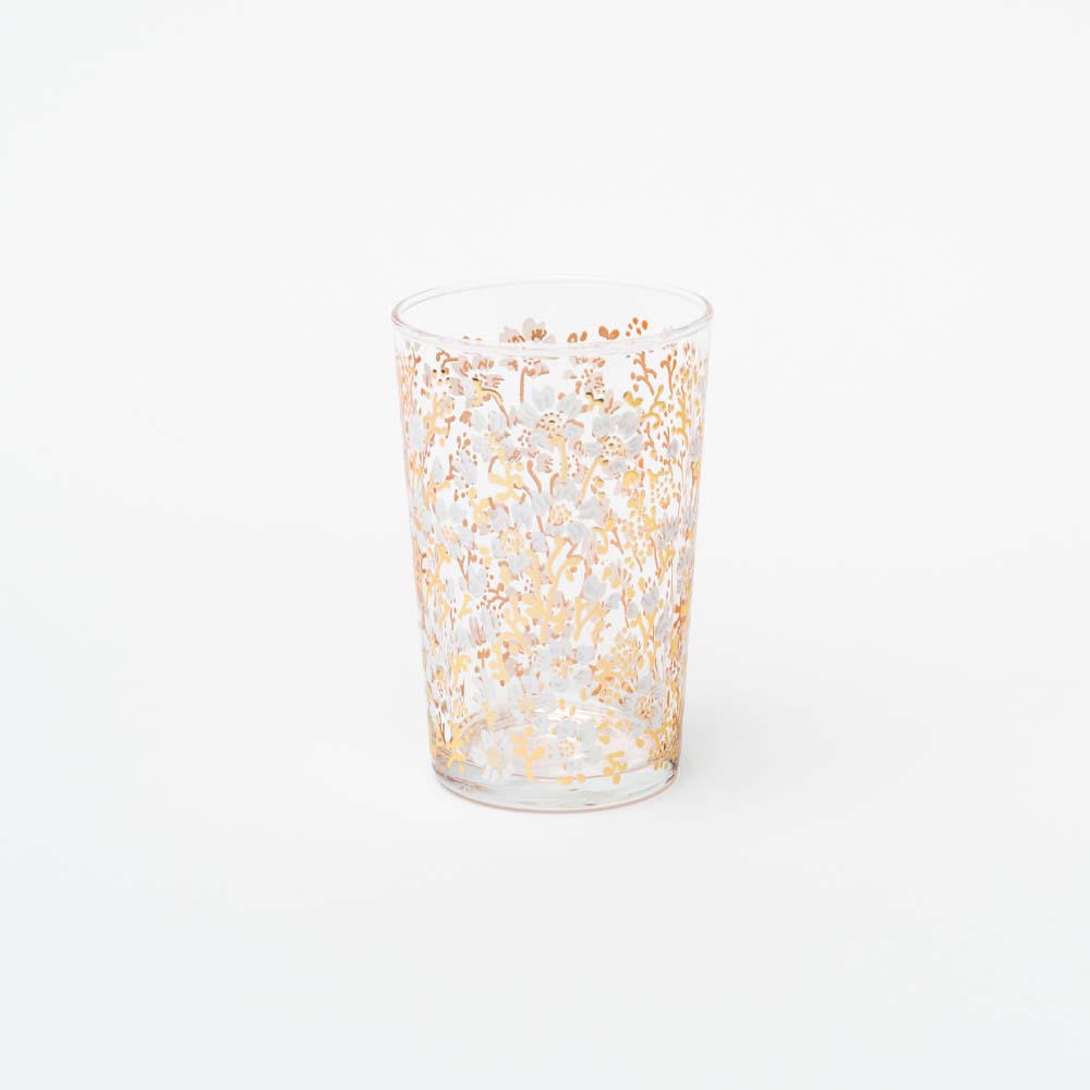 Single tea glasses with white and gold blossom design on a white background