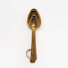 Brass finish measuring spoons on a white background