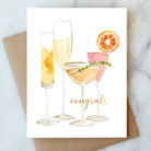 Congrats greeting card with champagne and cocktails on a marble surface