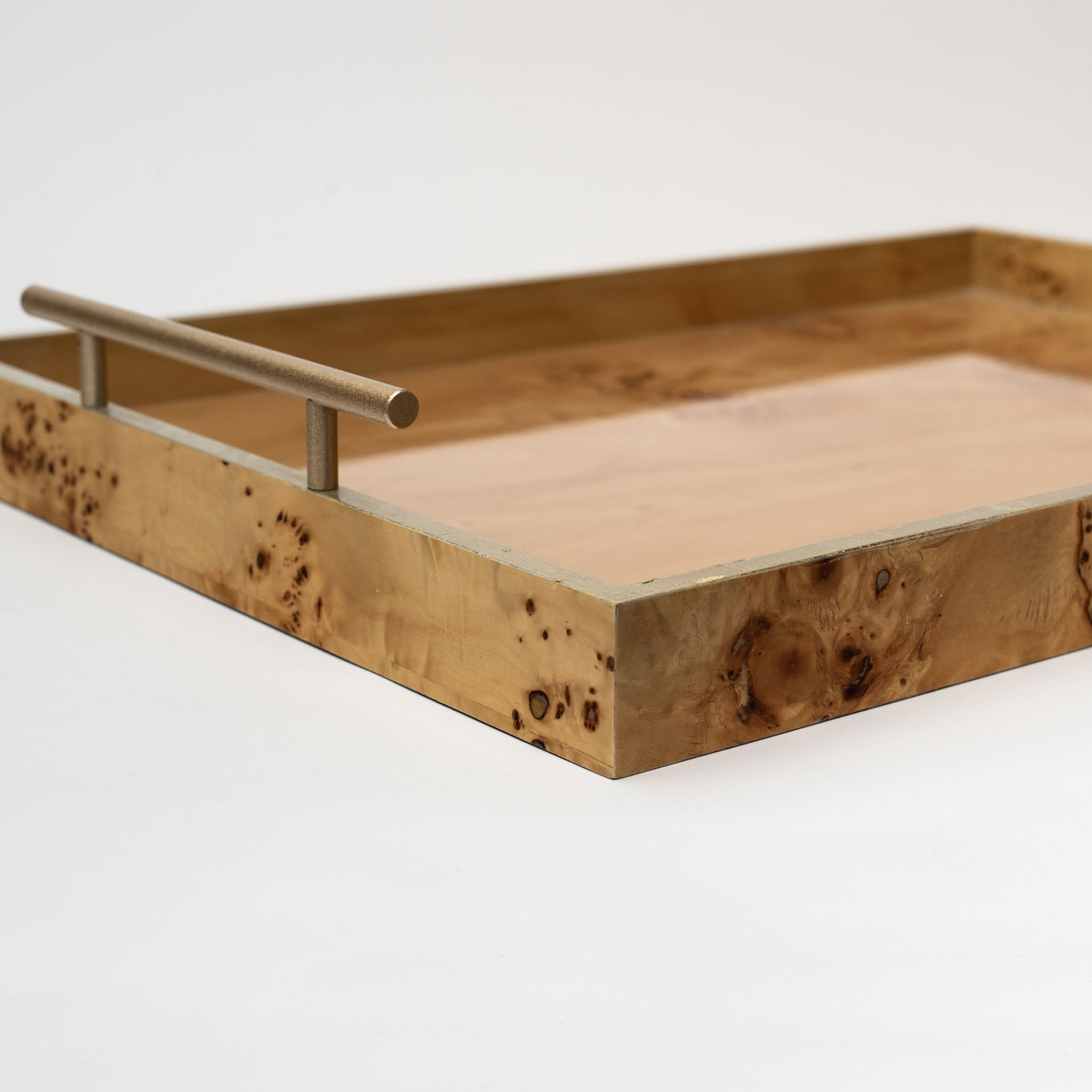 Close up of Burl wood tray with brass handles on a white background