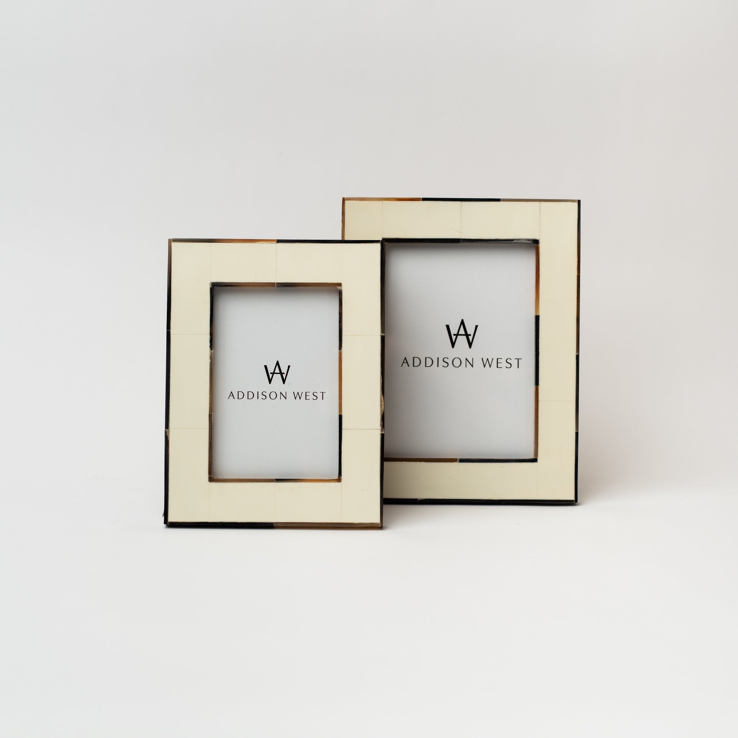 Two white picture frames with brown bone edges on a white background