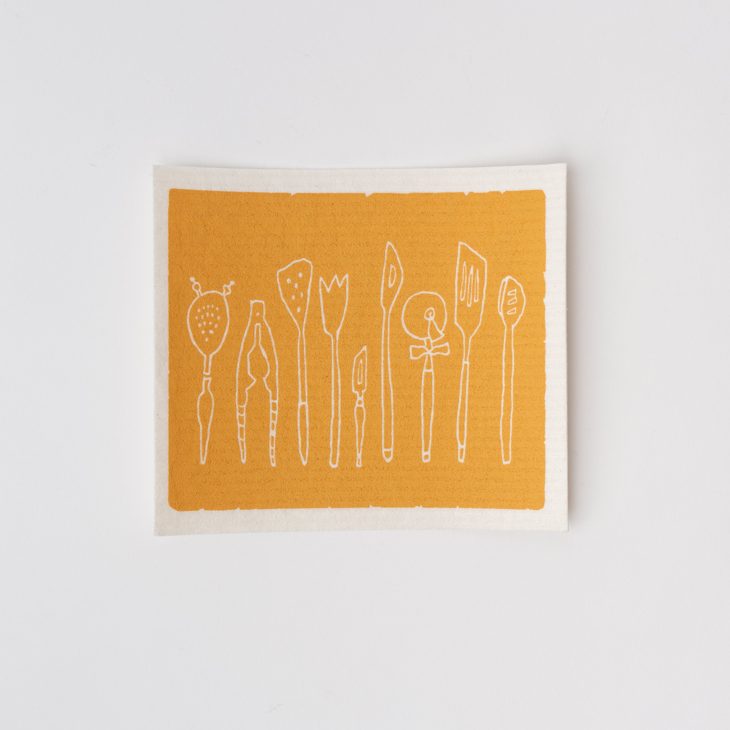 Swedish cloth sponge with kitchen utensils in a row and yellow background