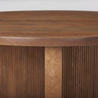 Round wood entry table with three legs with fluted finish on a white background