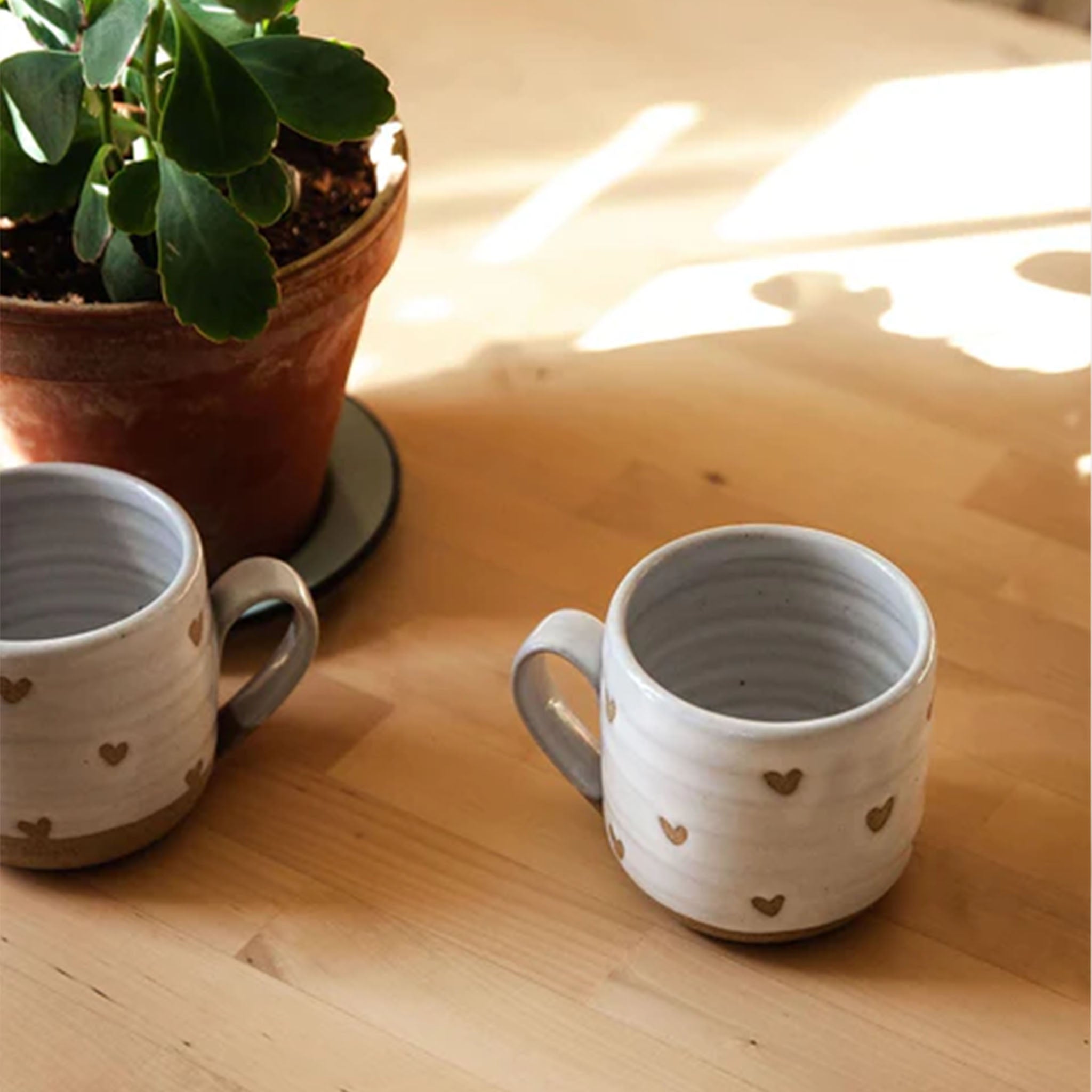 Farmhouse Pottery brand confetti heart mug on a wood counter