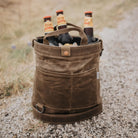 Bare bones brand foraging back in dark khaki on a gravel with beer bottles inside