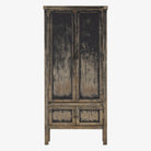 Tall 'Hitchens' cabinet with worn black paint and two doors on a white background by Four hands furniture