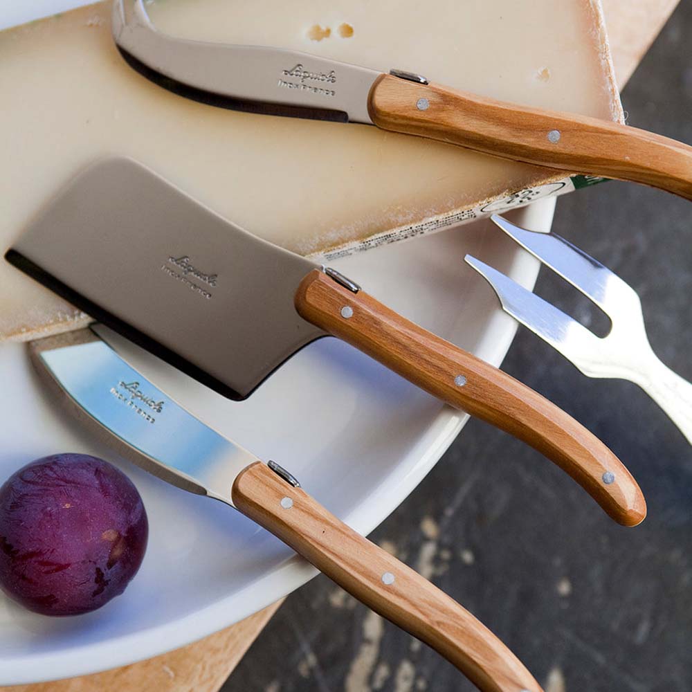 Laguiole olivewood cheese set in on a counter with cheese and fig