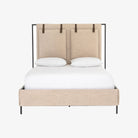 Upholstered 'Leigh' bed by Four hands furniture with metal frame and buckled head board panels on a white background