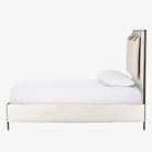 Upholstered 'Leigh' bed by Four hands furniture with metal frame and buckled head board panels on a white background