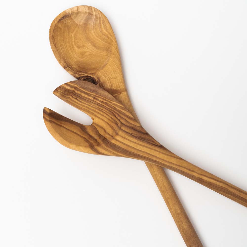 Close up of set of olive wood salad servers on a white background