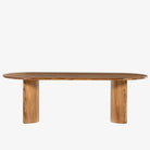 Light wood 'Paden' oval dining table by Four Hands Furniture with two legs to support thick top on a white background