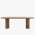 Seasoned dark wood 'Paden' oval dining table by Four Hands Furniture with two legs to support thick top on a white background