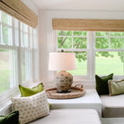 Room with white walls and built-in day beds and a seagrass tray with lamp on top