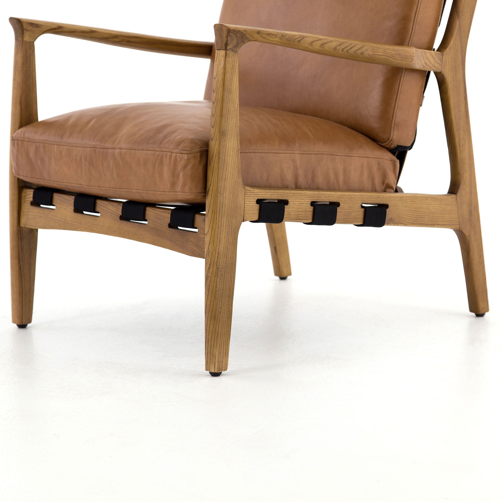 Four hands brand Silas arm chair with wood frame and patina copper leather cushions on a white background