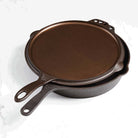 Smithey twelve inch flat top griddle shown on top of Smithey twelve inch pan on a white background