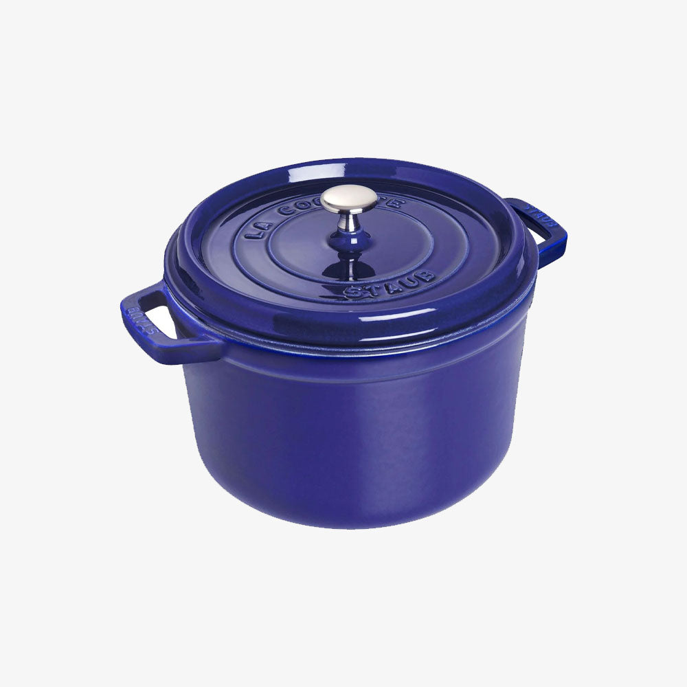 Blue Staub five quart cast iron dutch oven on a white background