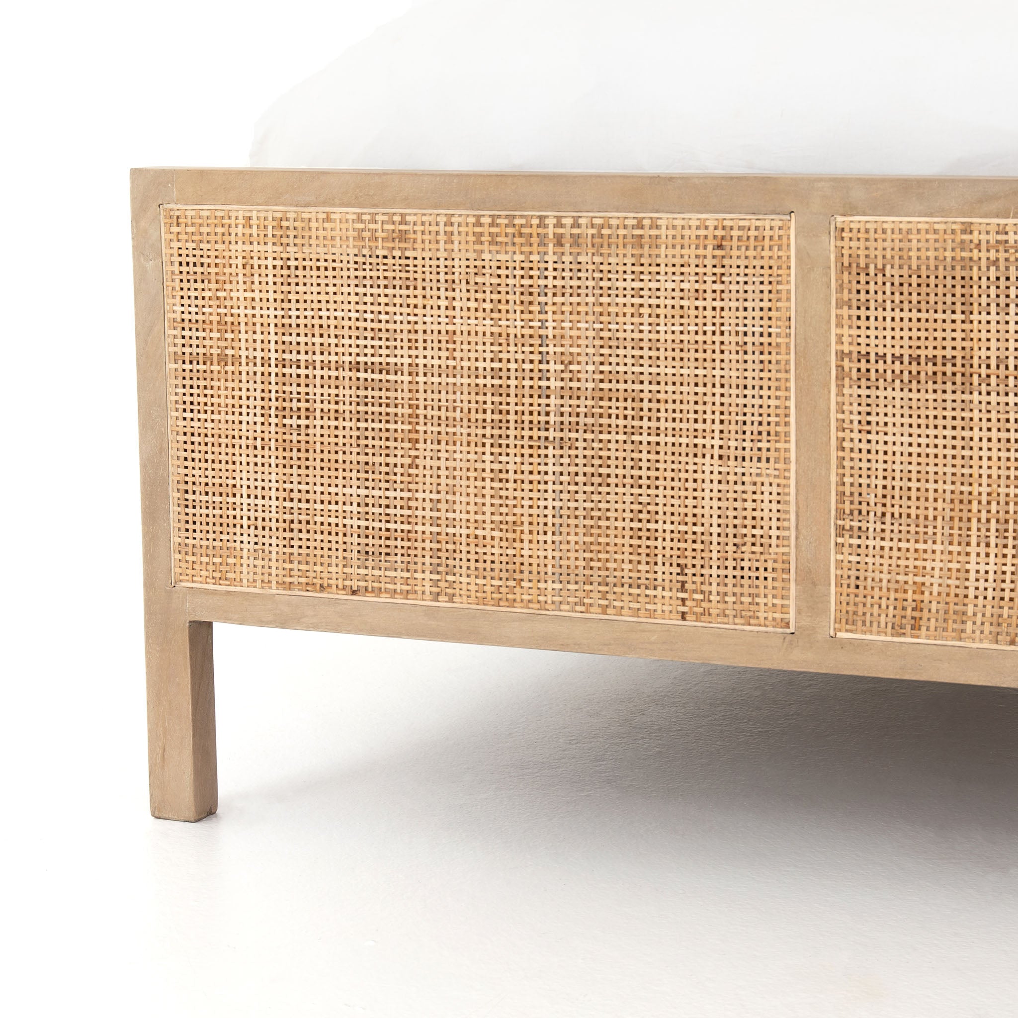 Close up of Natural wood and cane 'Sydney' bed by Four hands furniture on a white background