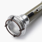 Barebones vintage flashlight in olive on a white background